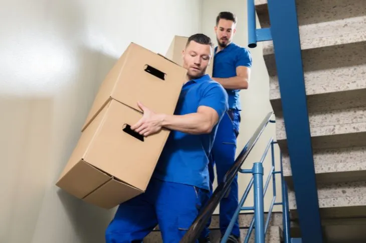 Movers carry boxes down the stairs Movers carry boxes down the stairs